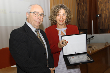 A homenageada Marina Lopes Ribeiro recebe placa do Grupo Ozônio, das mãos do senhor Wadi Tadeu Neaime.